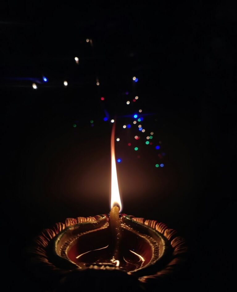 A lit diya candle glowing in the dark for Janmashtami celebrations